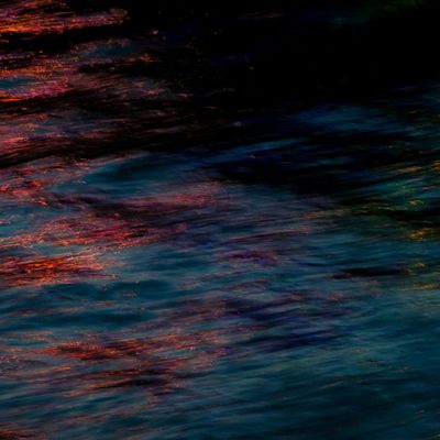 Close-up of calm water ripples with a blue hue.